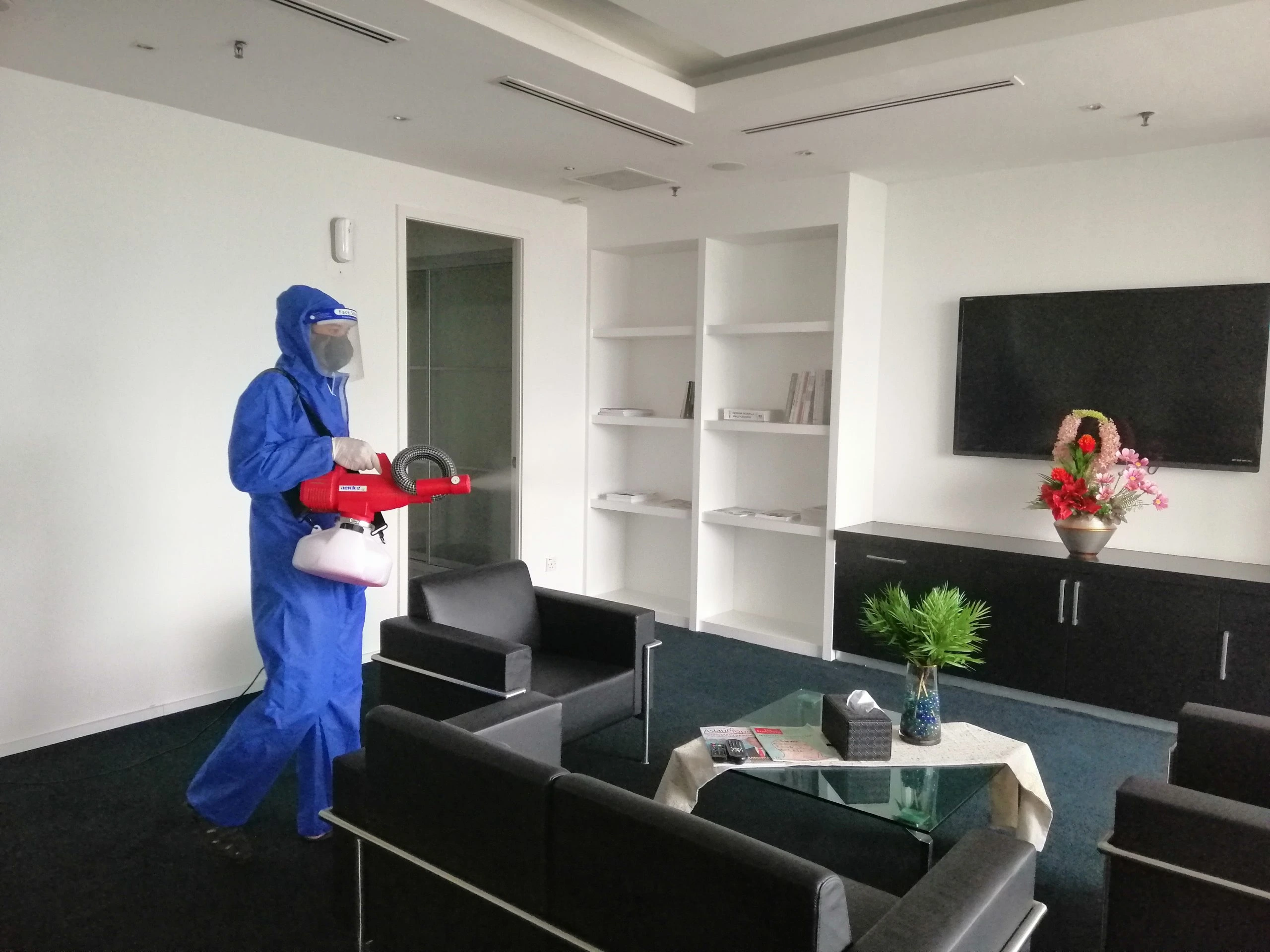 A technician from DNI Pest Control, the best pest control and exterminator Malaysia trusts, wearing a blue hazmat suit to treat an office space for a leading pest control company in malaysia.